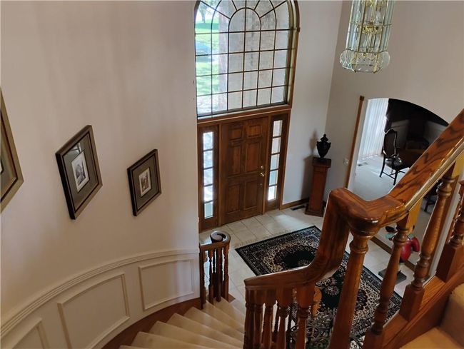 Entryway with tile patterned floors, a high ceiling, and stairs | Image 59