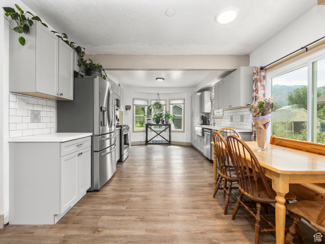 Kitchen with appliances with stainless steel finishes, light countertops, light wood-style floors, and decorative backsplash | Image 4
