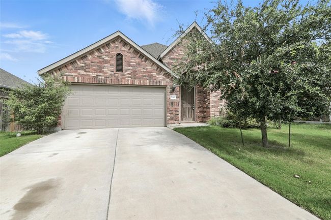 View of front facade with brick siding, driveway, a front lawn, and a garage | Image 5
