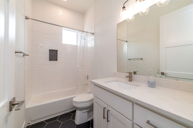 Bathroom with vanity, shower / tub combo with curtain, and tile patterned floors | Image 12