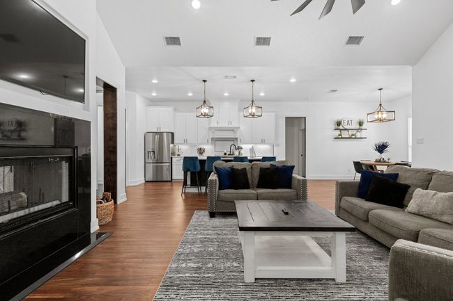 Living area with recessed lighting, visible vents, and dark wood-style flooring | Image 25