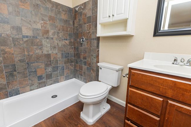 Bathroom with a shower, hardwood / wood-style floors, vanity, and toilet | Image 13