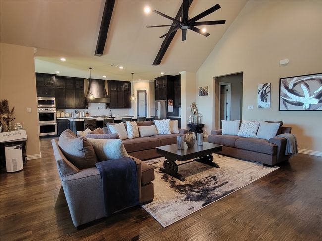 Living room with high vaulted ceiling, ceiling fan, dark wood-type flooring, and recessed lighting | Image 10