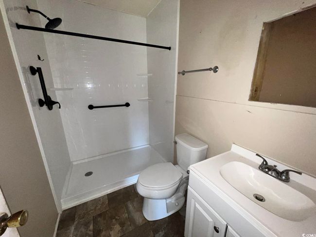 Bathroom featuring toilet, walk in shower, vanity, and stone finish flooring | Image 8