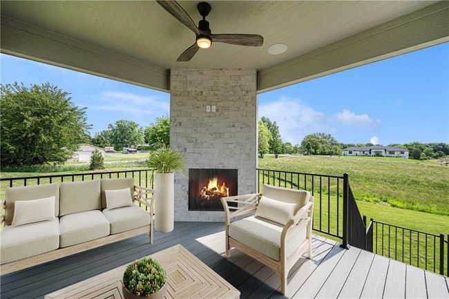 Deck with an outdoor living space with a fireplace, a ceiling fan, and a lawn | Image 59