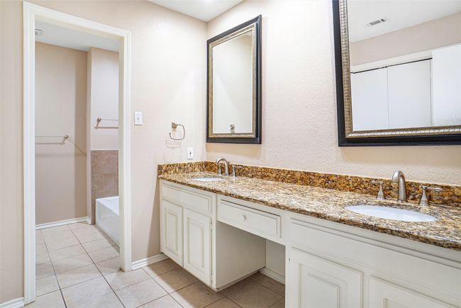 Full bathroom featuring double vanity, tile patterned floors, a bath, and baseboards | Image 7