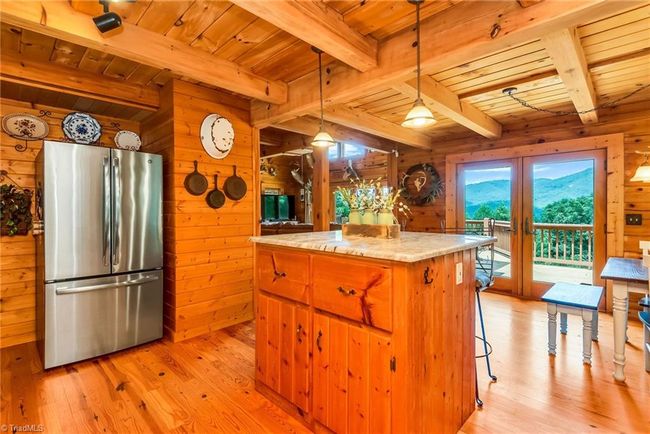 The master bedroom showcases a serene ensuite bathroom featuring a spacious garden tub with picturesque views of North Carolina mountains, complemented by an all-wood interior and elegant granite countertops, creating a luxurious retreat. | Image 25