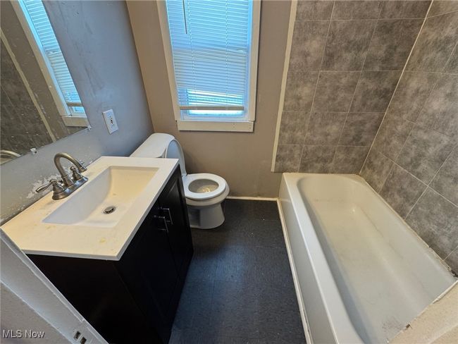 Full bathroom with toilet, vanity, tile patterned floors, and baseboards | Image 10