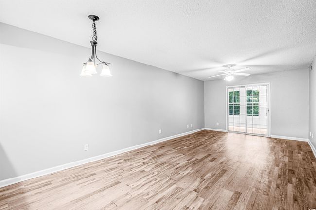 Spare room with wood finished floors, ceiling fan, and a textured ceiling | Image 11