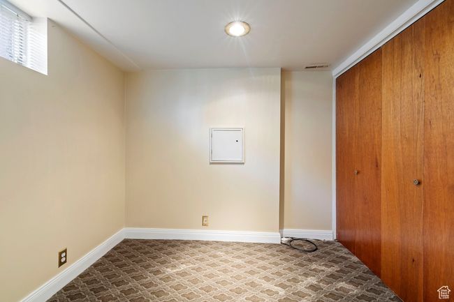 Unfurnished bedroom with a closet, tile patterned floors, and electric panel | Image 22