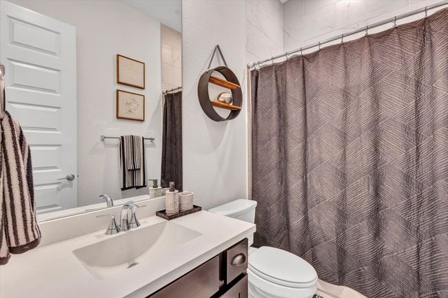 A stylish full bathroom with a shower that is tiled from floor to ceiling. | Image 7