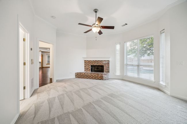 Primary bedroom with carpet floors, crown molding, ceiling fan, and a fireplace | Image 16
