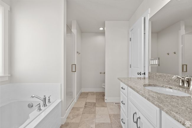 Full bathroom featuring vanity, a shower stall, and a garden tub | Image 19