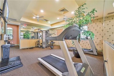 Workout area featuring a tray ceiling, carpet flooring, and ceiling fan | Image 3