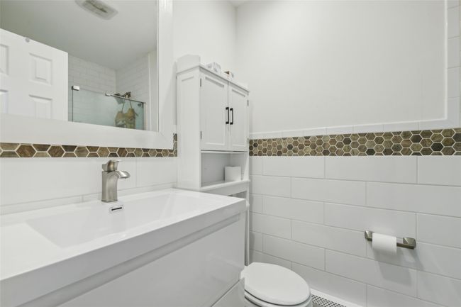 Bathroom featuring vanity, visible vents, tiled shower, tile walls, and toilet | Image 19