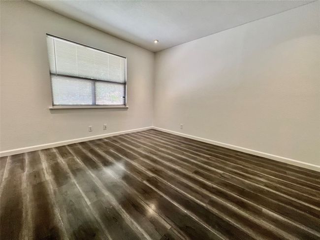 Unfurnished room with dark wood-style floors and baseboards | Image 15