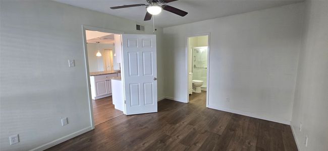 Unfurnished bedroom featuring dark wood finished floors, ensuite bathroom, and a ceiling fan | Image 4