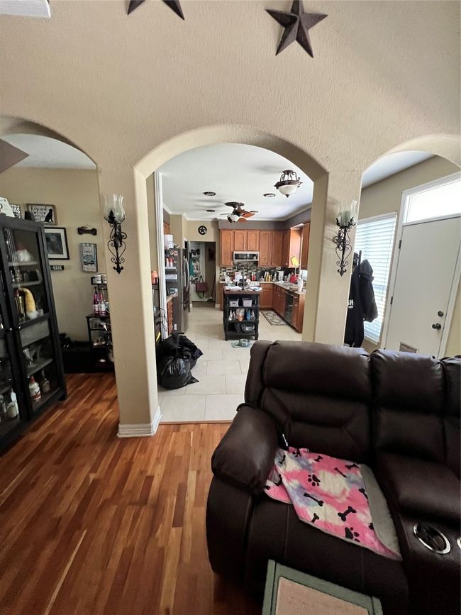 Living area featuring a ceiling fan, arched walkways, and light wood finished floors | Image 8