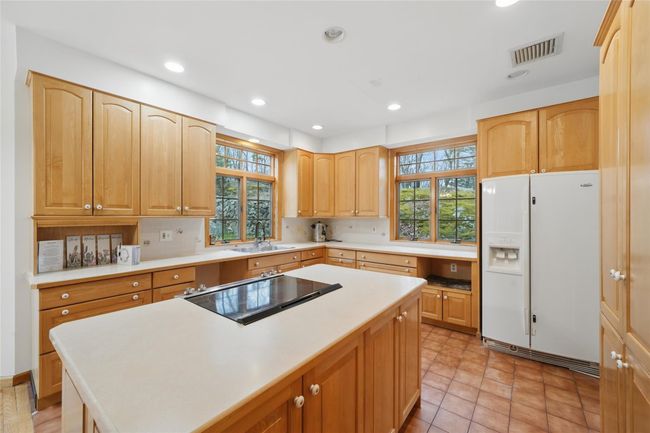 Kitchen featuring a sink, visible vents, a kitchen island, light countertops, and white fridge with ice dispenser | Image 13