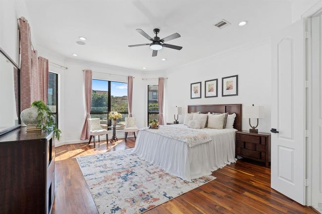 Primary bedroom suite featuring a bay window with a view of the pool, crown molding, and high ceilings, creating a luxurious and relaxing retreat. | Image 19