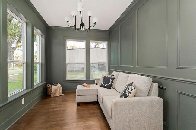 Through the elegant glass French doors, the formal living room or office space offers versatility & style. It offers two walls of windows that flood the room with natural light, complemented by the restored orginal hardwood floors, crown molding, & picture-frame molding. | Image 9