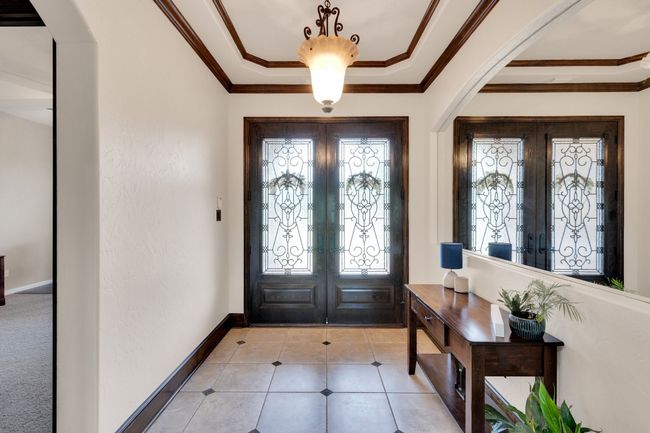 Entryway with a healthy amount of sunlight, french doors, and crown molding | Image 5