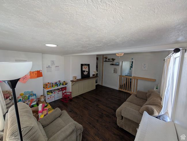 Living room featuring wood finished floors and a textured ceiling | Image 14