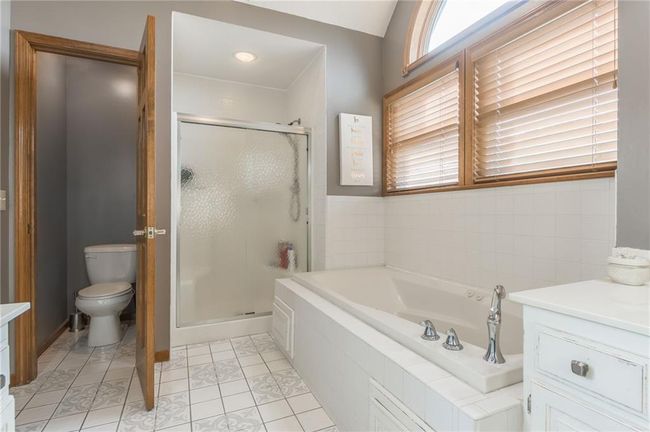 Bathroom featuring toilet, vanity, a bath, and a shower stall | Image 49
