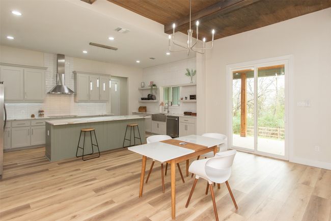 Dining room featuring wooden ceiling, an inviting chandelier, sink, light hardwood / wood-style flooring, and beamed ceiling | Image 15