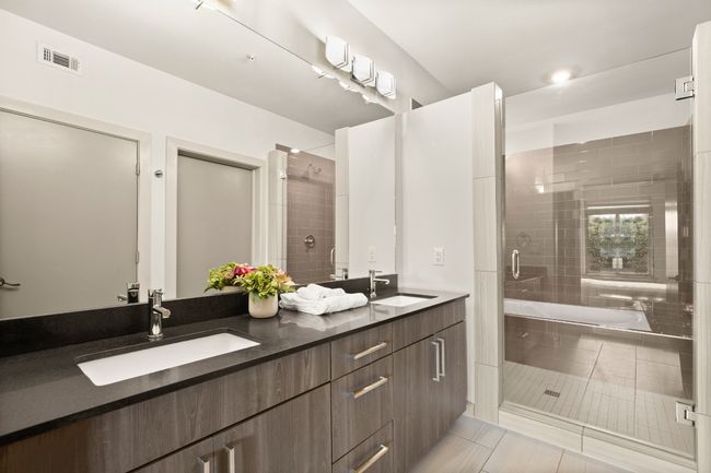Full bathroom featuring a stall shower, double vanity, tile patterned flooring, and a bathtub | Image 17