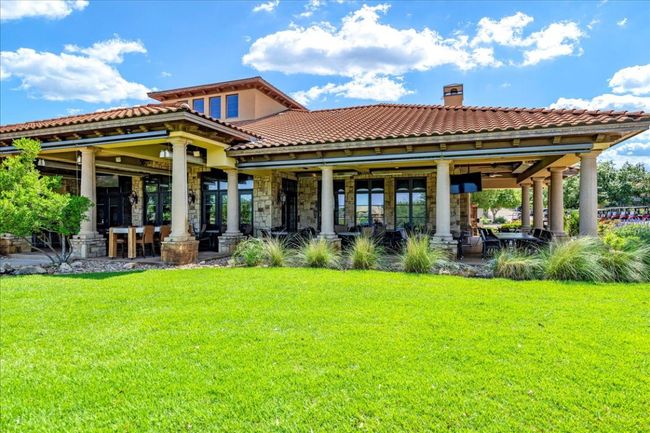 Rear view of property with a lawn, a chimney, a tiled roof, and stone siding | Image 39