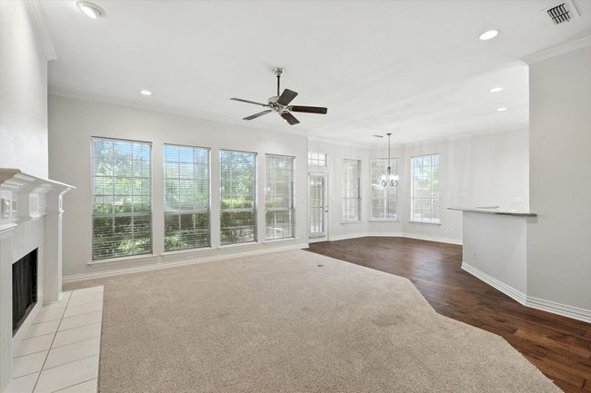 Family room featuring crown molding, ceiling fan, recessed lighting, a chandelier, and a fireplace | Image 10