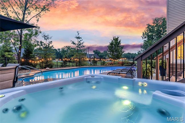 Pool at dusk with a hot tub | Image 5