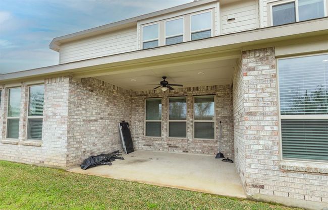 covered patio area with a ceiling fan | Image 34