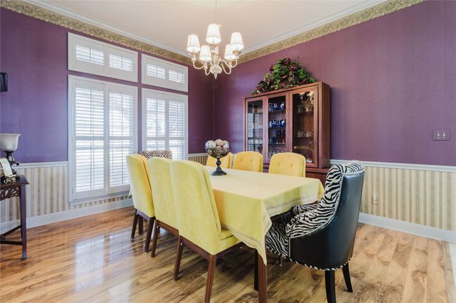 Dining space with light wood-type flooring, crown molding, and a notable chandelier | Image 13