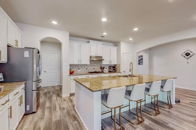 Kitchen with a sink, arched walkways, stainless steel appliances, under cabinet range hood, and recessed lighting | Image 15