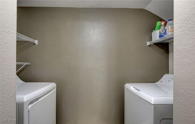 Laundry area featuring a textured wall, laundry area, and washer and clothes dryer | Image 19