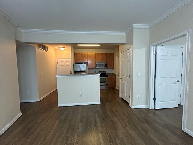 Kitchen featuring visible vents, baseboards, ornamental molding, appliances with stainless steel finishes, and brown cabinets | Image 19