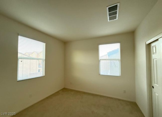 Carpeted empty room with a wealth of natural light and visible vents | Image 8