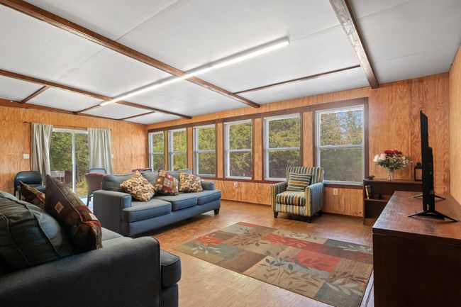 Living room featuring wood-type flooring and wood walls | Image 8