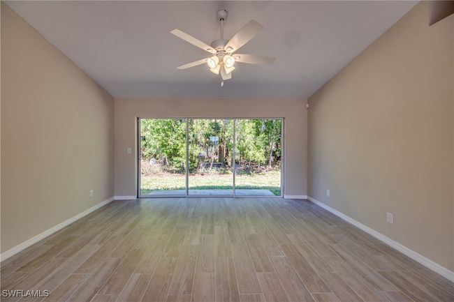 Unfurnished room with ceiling fan, wood finished floors, and baseboards | Image 16