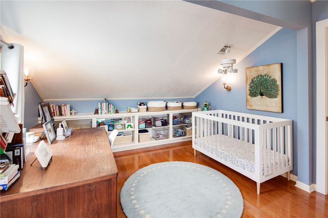Bedroom with vaulted ceiling, wood finished floors, and crown molding | Image 22