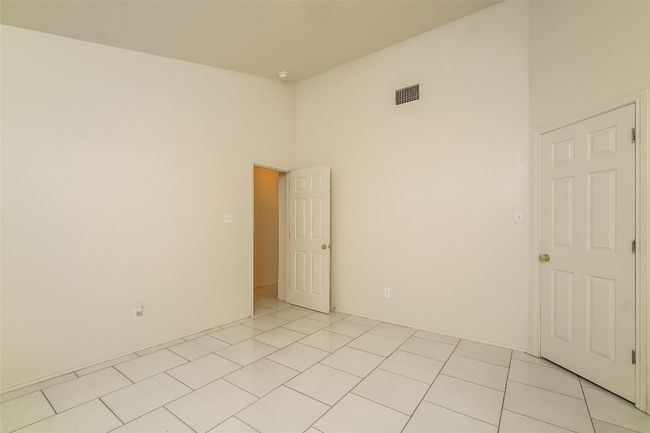 Unfurnished room featuring a towering ceiling and light tile patterned floors | Image 13