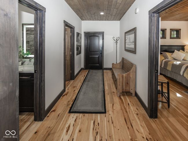 hallway with light wood finished floors, wooden ceiling, and baseboards | Image 25