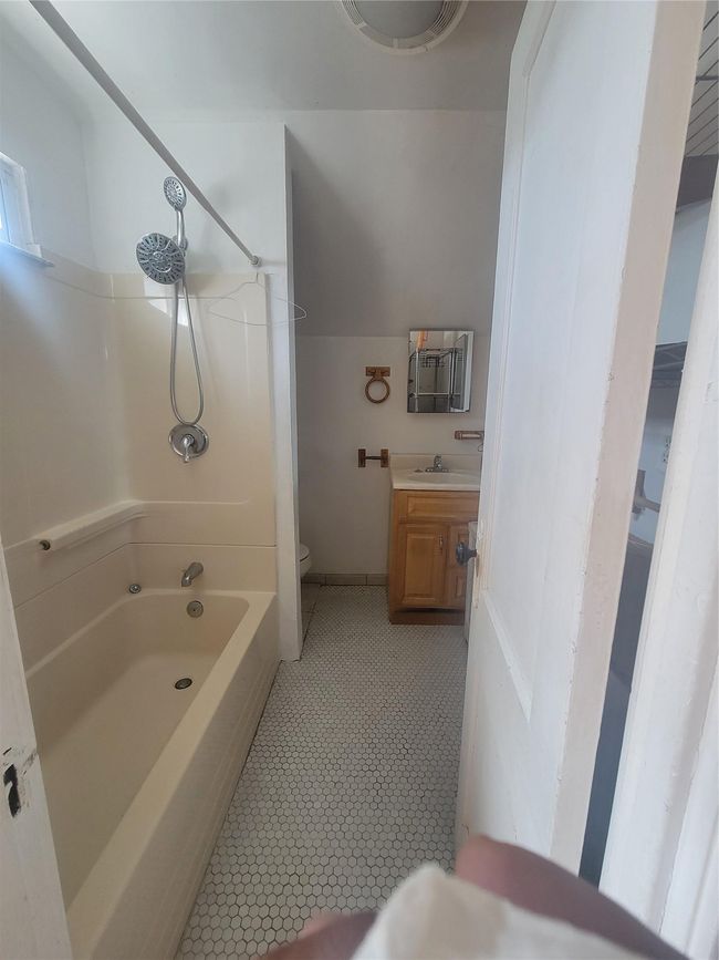 Bathroom featuring toilet, tile patterned floors, vanity, and shower / washtub combination | Image 11