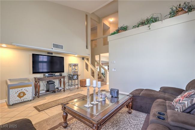 Tiled living room featuring a towering ceiling and stairway | Image 7