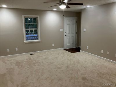 Living room featuring carpet flooring and ceiling fan. | Image 2