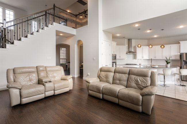 Living room with arched walkways, dark wood-type flooring, and baseboards | Image 9