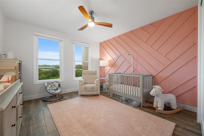 Secondary bedroom with artistic woodwork accent wall overlooking Shoal Creek Greenbelt. | Image 22