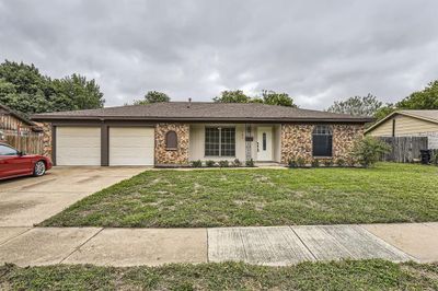 Ranch-style home with a front yard and a garage | Image 2